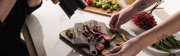 bijgesneden weergave van commerciële fotografen maken fotoshoot van voedsel op digitale camera - Foto, afbeelding
