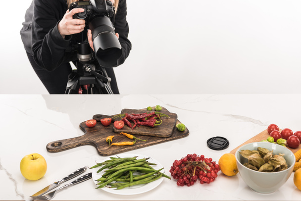 обрезанный вид женщины-фотографа, делающей пищевую композицию для коммерческой фотографии и фотографирующей на цифровую камеру
  - Фото, изображение