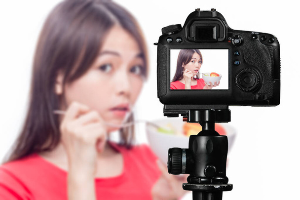 Asian food vlogger with fruit salad behind camera - Photo, Image