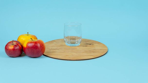 Taze üzümlü bir bardak meyve suyu ve mavi arka planda elmalar.. - Fotoğraf, Görsel