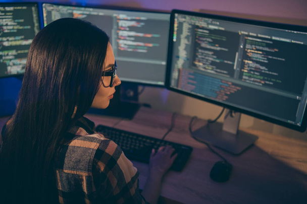 Photo of serious confident focused girl concentrated on hacking the security code of her opponents in spectacles using java script - Foto, imagen
