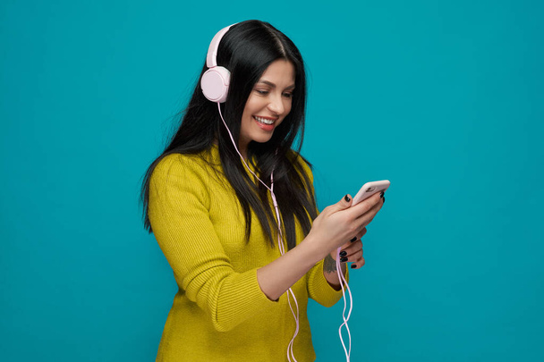 Stylish young woman listening music with headphones. - Zdjęcie, obraz