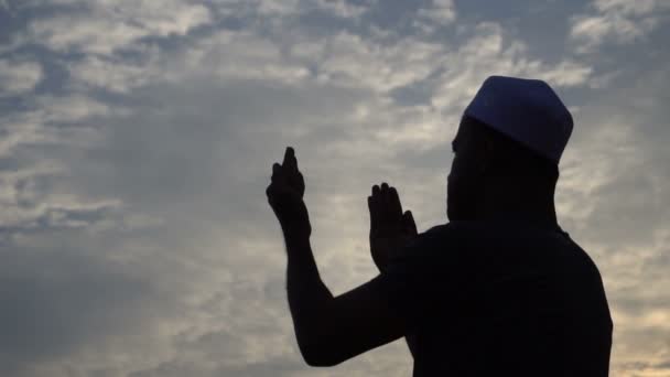 Młody muzułmanin azjatycki modli się o zachodzie słońca - Materiał filmowy, wideo
