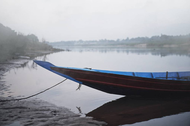 La barca a remi del pescatore è parcheggiata sulla riva del fiume nelle prime ore del mattino
 - Foto, immagini
