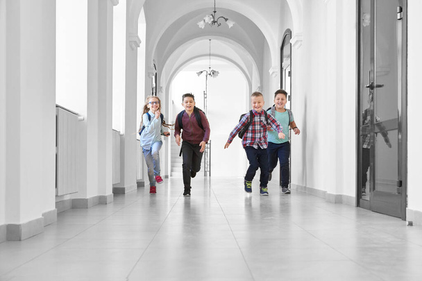 Pupils playing together and running on school corridor. - Фото, изображение