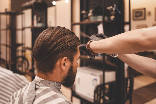 hairdresser is applying hair spray to the clients hair. barber using hair spray - Fotoğraf, Görsel