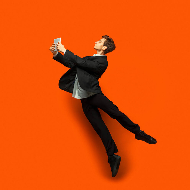 Man in casual office style clothes jumping isolated on studio background - Foto, immagini