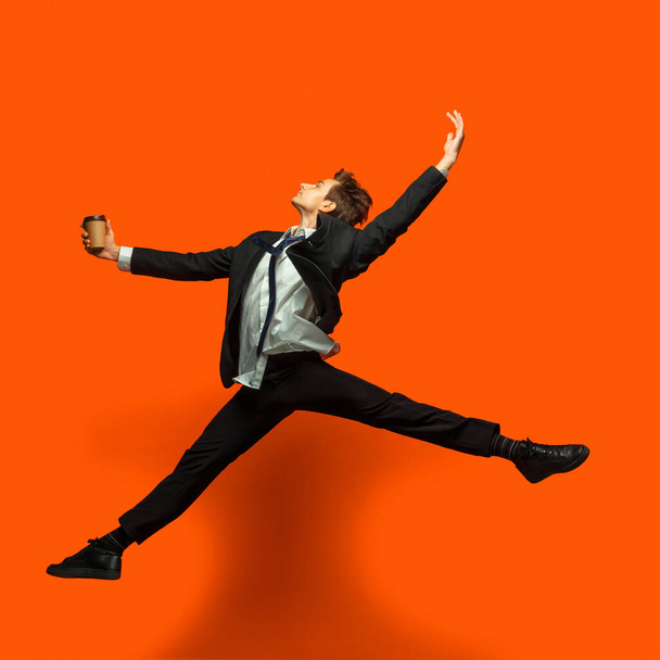 Man in casual office style clothes jumping isolated on studio background - Fotoğraf, Görsel