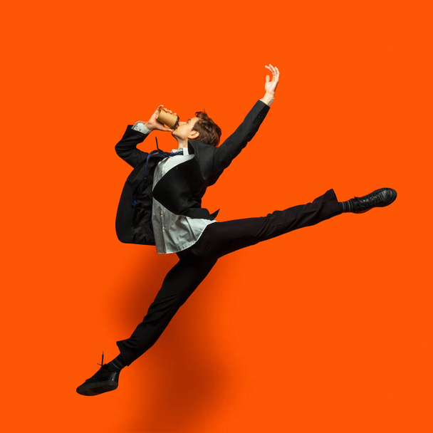 Man in casual office style clothes jumping isolated on studio background - Fotó, kép