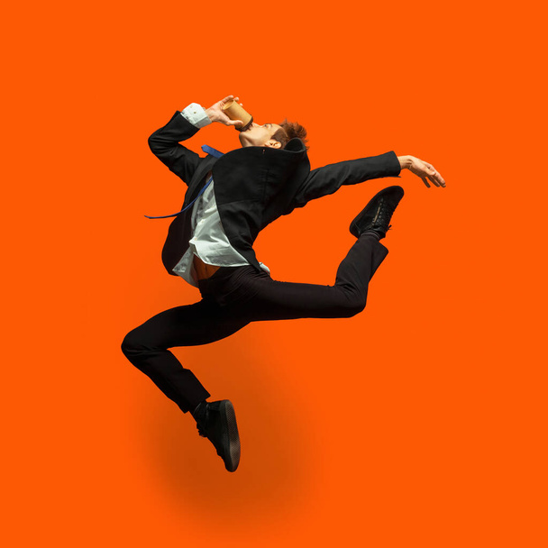 Man in casual office style clothes jumping isolated on studio background - Foto, Bild