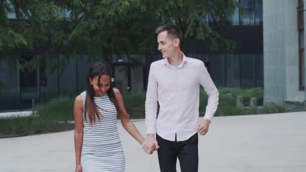 Multiracial couple running together along the street - Video, Çekim