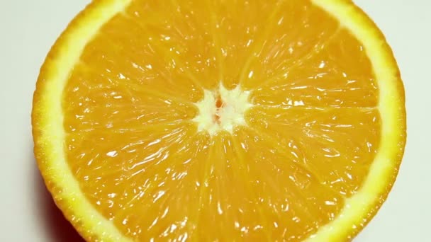 Drops of water flow down a juicy ripe orange. Fruit close-up. Orange on a white background. - Video
