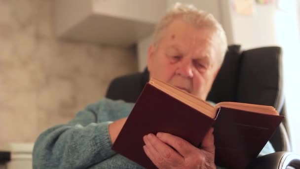 Old wishing woman reads a book close up - Felvétel, videó