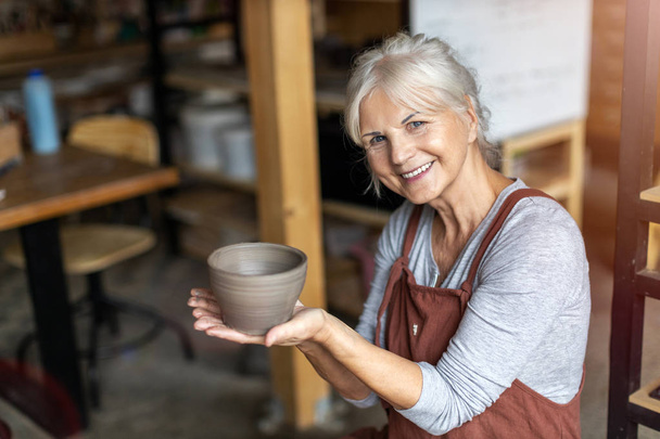 Portrait of senior female pottery artist in her art studio - Foto, Imagem