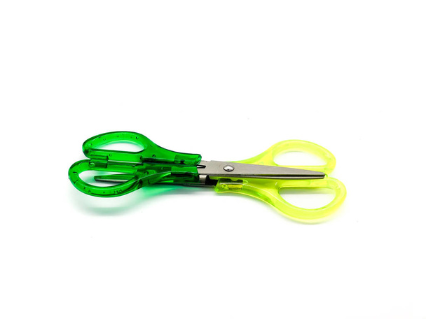 Green and yellow scissors isolated on a white background. Composition of scissors. - Photo, Image