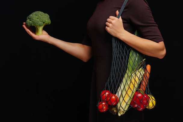 Žena drží opakovaně použitelný řetězec taška plná čerstvé zeleniny přes - Fotografie, Obrázek