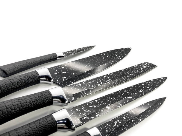 Composition of black knives isolated on white background. Composition of the chef knife, bread knife, carving knife, utility knife. Professional Set. Sharp blade in white dots - Photo, Image