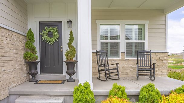 Panorama çerçeve ev cephesi, merdivenlerle verandaya, sütunlarla ve çelenkli gri kapıyla. - Fotoğraf, Görsel