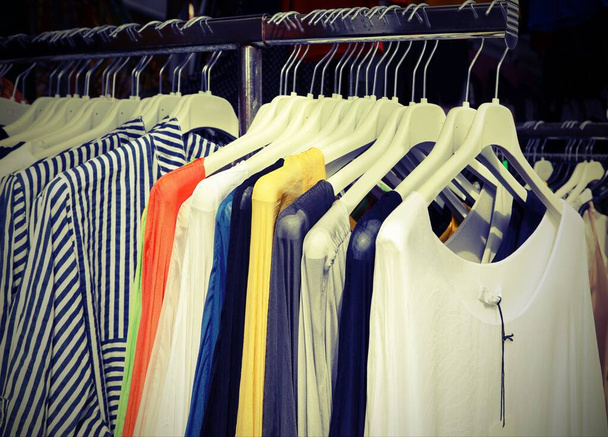 Kleider auf dem Kleiderständer am Marktstand mit antiquiertem Colo - Foto, Bild