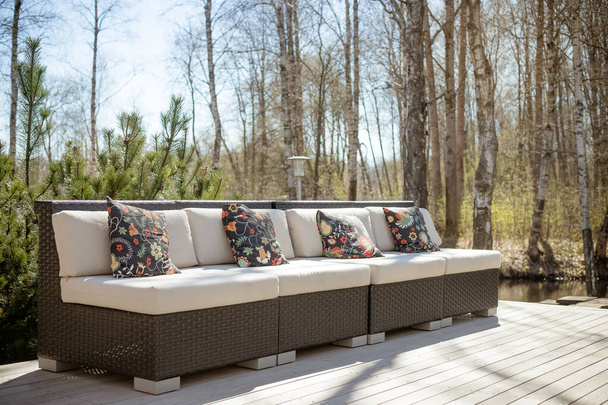 Large terrace patio with rattan garden furniture set.Wooden garden lounge chair with cushion. comfortable rattan sofa. relaxing area outside .patio with furniture on wooden floor.relaxation on the - Photo, Image
