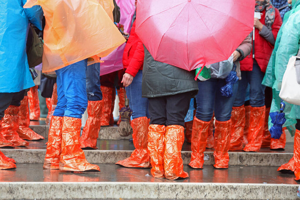 esőkabátos és lábszárvédős emberek árvíz idején - Fotó, kép