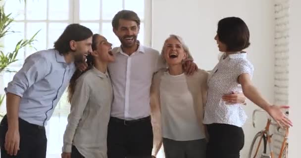 Podekscytowany wielonarodowy zespół biznesowy ludzie obejmują śmiech świętować sukces korporacyjny - Materiał filmowy, wideo