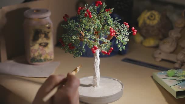 Künstlerin bemalt den handgefertigten Drahtbaum vor dem Lackieren - Filmmaterial, Video