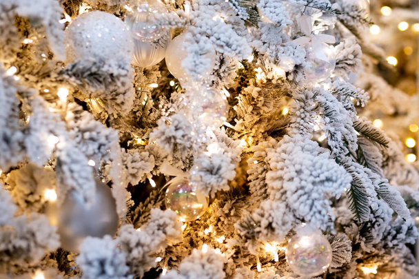 Christmas white tree decorated snow illumination and gifts toys, background light bokeh - Photo, Image