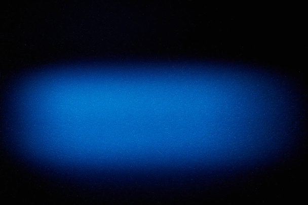 На чорному тлі горизонтальна розмита хмара синього кольору
 - Фото, зображення
