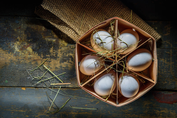яйца в коробке на фоне досок
 - Фото, изображение