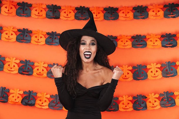 Image of delighted witch woman in black halloween costume scream - Foto, Imagem