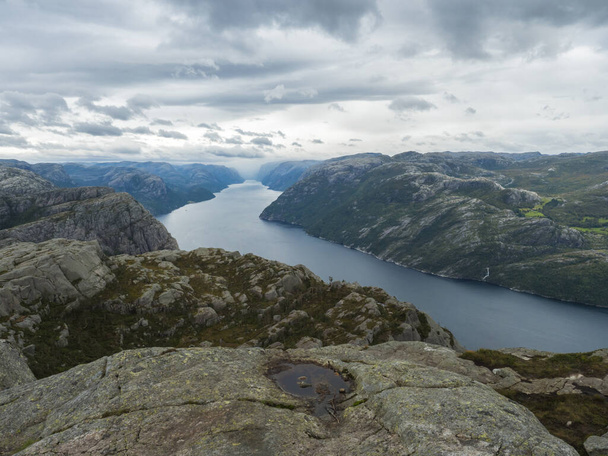 フィヨルドLysefjordでの眺めPreikestoled大規模な崖の横にある有名なノルウェーの視点ムーディスカイ、秋の日。自然と旅行の背景、休暇とハイキング休暇のコンセプト. - 写真・画像