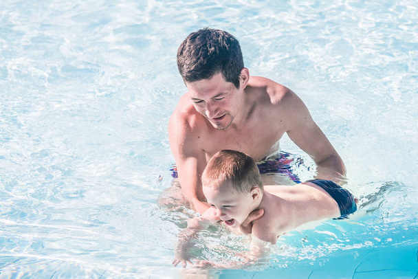 Babasıyla oğlu yüzme havuzunda. Babalar Günü. - Fotoğraf, Görsel