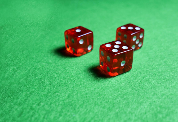 Τρία κόκκινα ζάρια σε πράσινο πανί, έννοια παιχνίδια καζίνο - Φωτογραφία, εικόνα