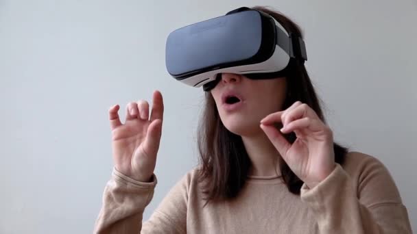 Souriez jeune femme portant en réalité virtuelle casque de lunettes VR casque sur fond blanc. Smartphone utilisant des lunettes de réalité virtuelle. Technologie, simulation, hi-tech, concept de jeu vidéo. - Séquence, vidéo