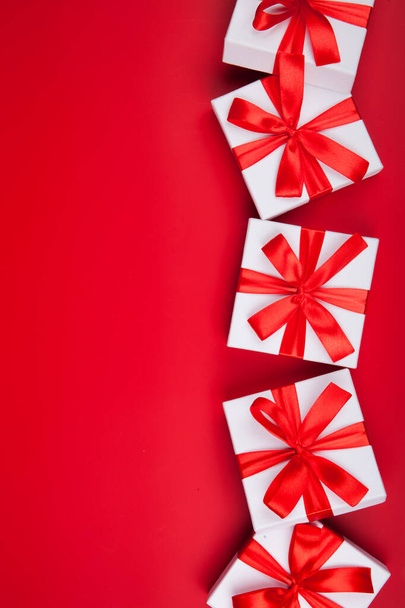 Christmas white gift presents on red background. Top view with copy space. Vertical - Foto, afbeelding