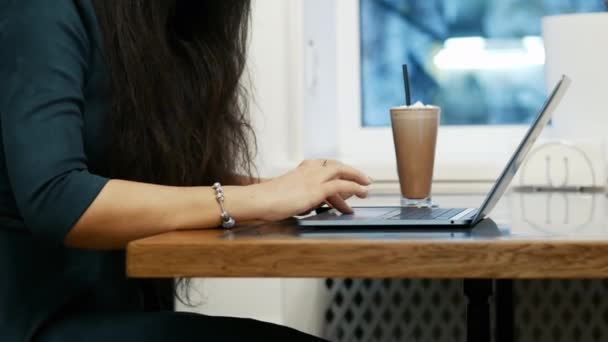 Close-up de mãos femininas, mulher de negócios moderna trabalha em um laptop enquanto está sentado no café, usando touchpad
 - Filmagem, Vídeo