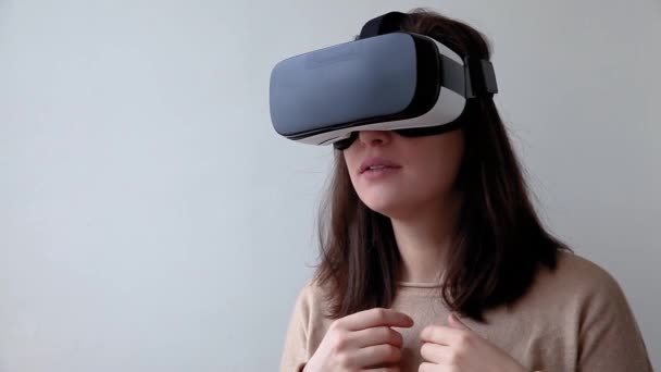 Lach jonge vrouw dragen met behulp van virtual reality VR bril helm headset op witte achtergrond. Smartphone met virtual reality bril. Technologie, simulatie, hightech, videogame concept. - Video