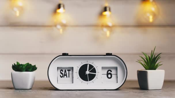 A white flip clock on table turns through month, flipping days and date, countdown from 1st to 31th - Footage, Video