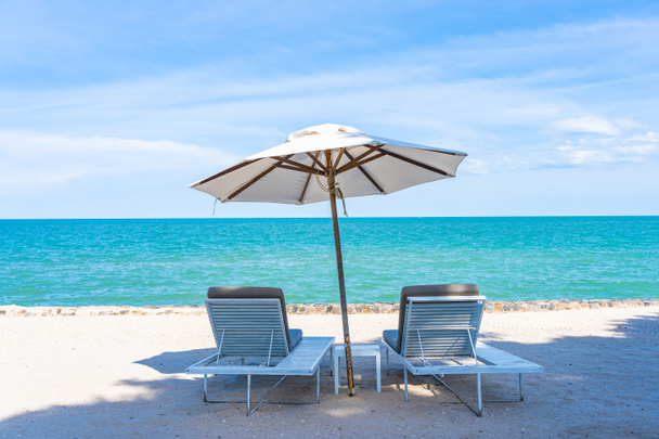 Mooie paraplu en stoel rond strand zee oceaan met blauwe SK - Foto, afbeelding