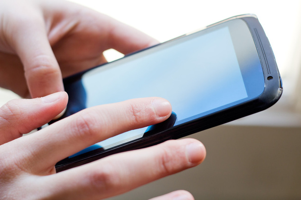 Girl hand touching screen on smart phone - Foto, afbeelding