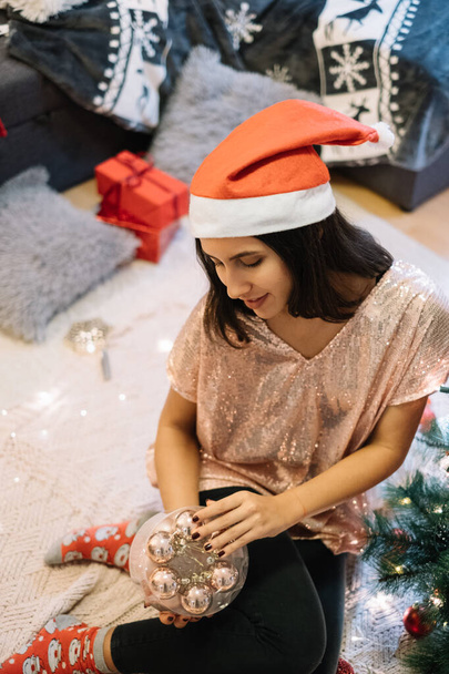 Woman in rose gold top decorating for Christmas - Zdjęcie, obraz