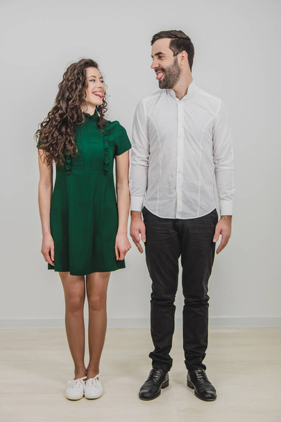 Funny boy and girl on white background, pulling faces looking at one another. - Foto, afbeelding