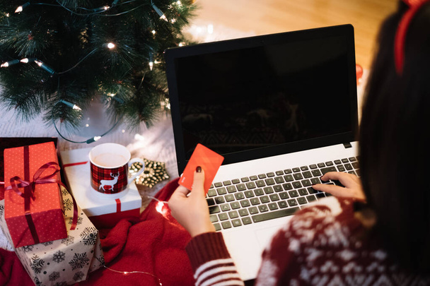 Fille en utilisant un ordinateur portable sur le sol près de cadeaux de Noël
 - Photo, image