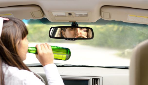 Жінка водій п'є за кермом
 - Фото, зображення