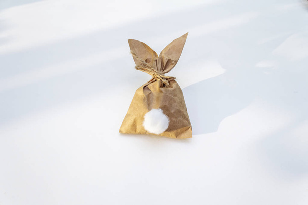 Lapin de Pâques (lapin) idée d'emballage cadeau en papier. Sur fond blanc au soleil
 - Photo, image