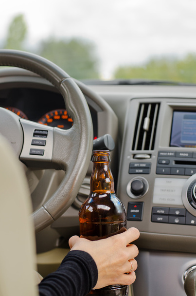 女性がアルコールの瓶を持って運転 - 写真・画像