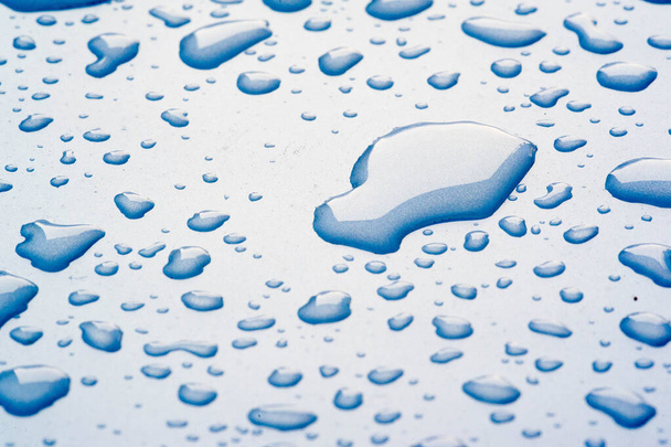 zomer regen, druppels water op de auto verf. een kleine ronde of p - Foto, afbeelding