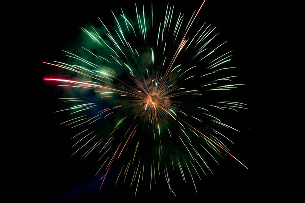 Center zöld narancs csillogó tűzijáték háttér éjszakai jelenet - Fotó, kép