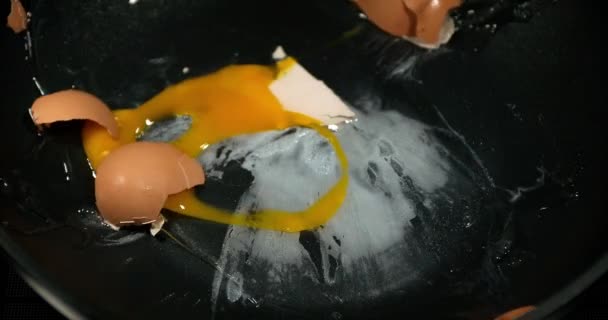 Egg bursting into a stove, slow motion 4K - Кадры, видео